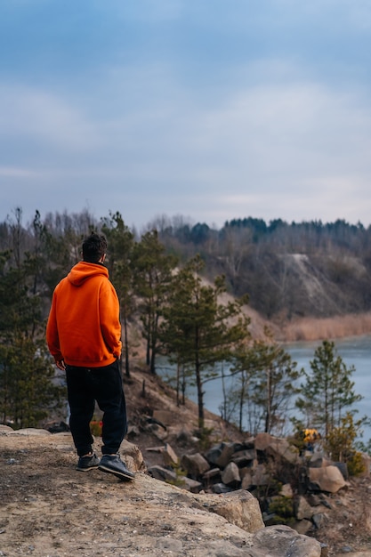 Free Photo a young man standing on the edge of a cliff