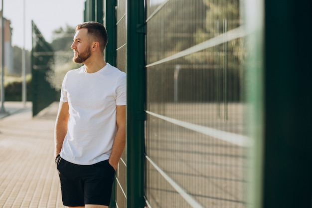 Free Photo young man standing at stadium in the morning