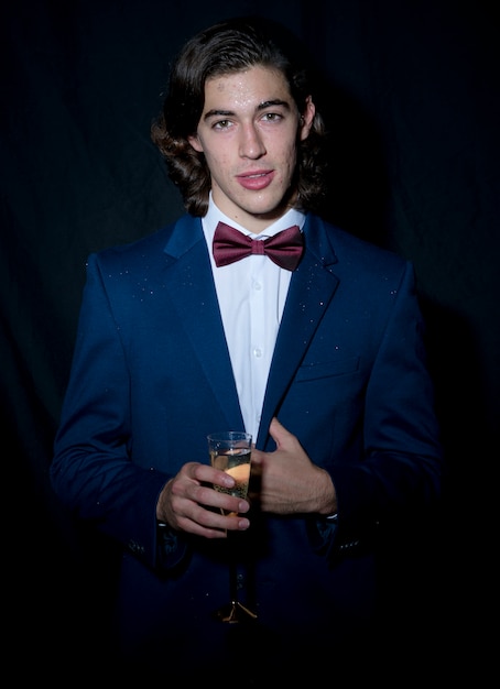 Free Photo young man standing with champagne glass 