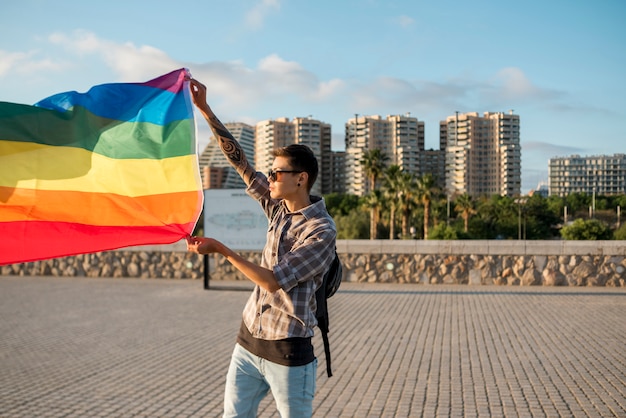 Young man standing with LGBT flag