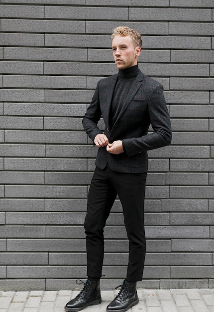 Young man on the street closing his jacket