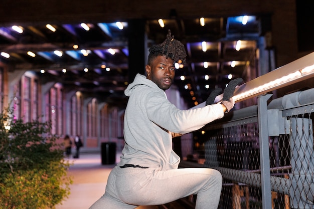 Young man stretching at night in the city