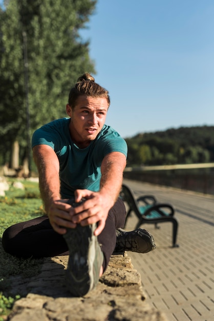 Free photo young man stretching in the park