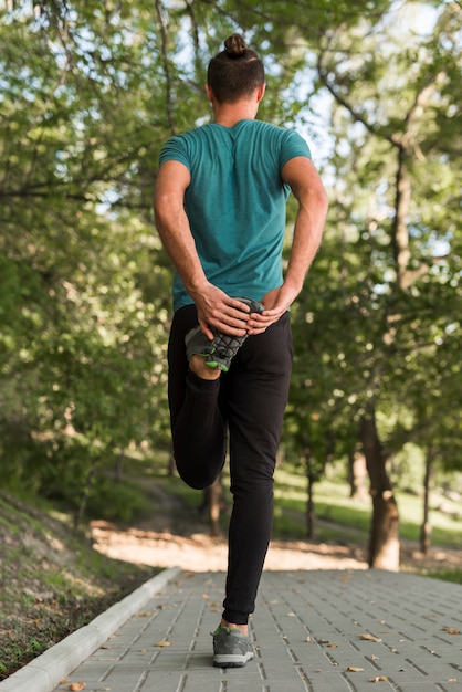 Free photo young man stretching in the park