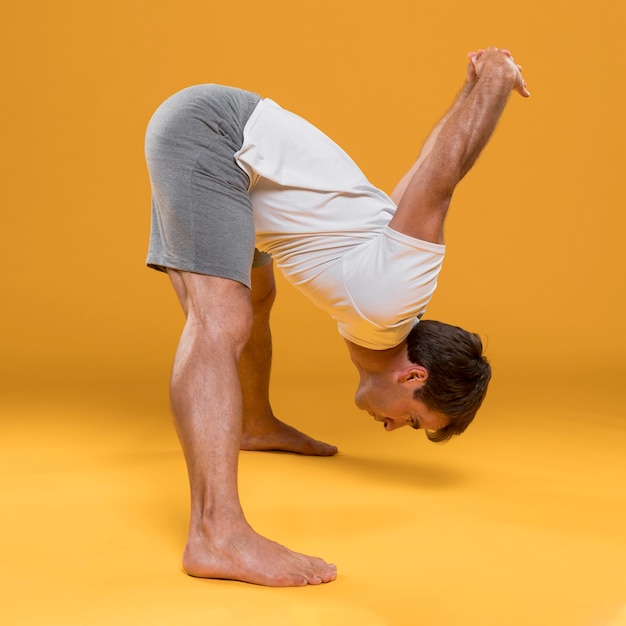 Free photo young man stretching in yoga pose