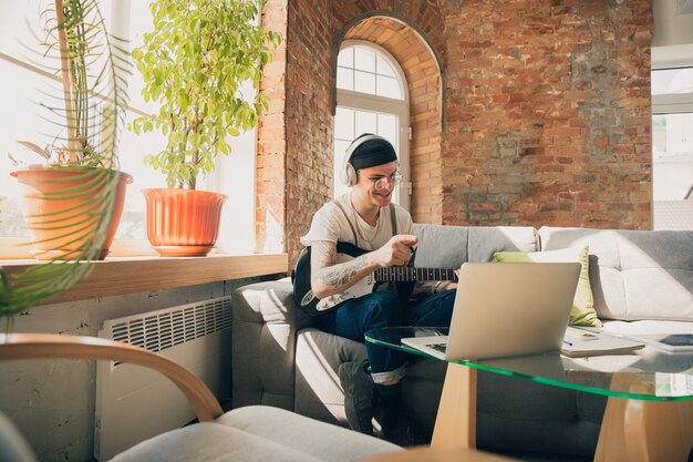 Young man studying at home during online courses or free information by hisself