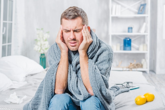 Free photo young man suffering from cold having headache