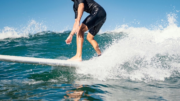 Free photo young man surfs ocean clear water waves