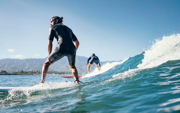 Young man surfs ocean waves