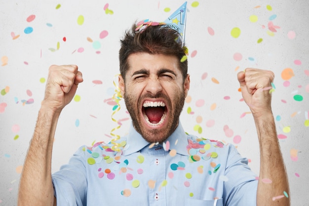 Free photo young man surrounded by confetti