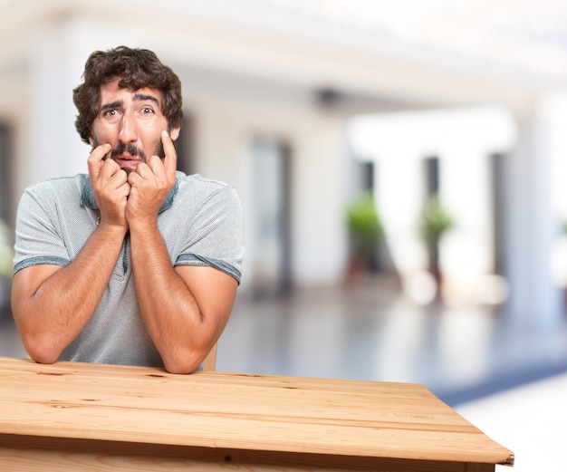 Free photo young man on a table. worried expression