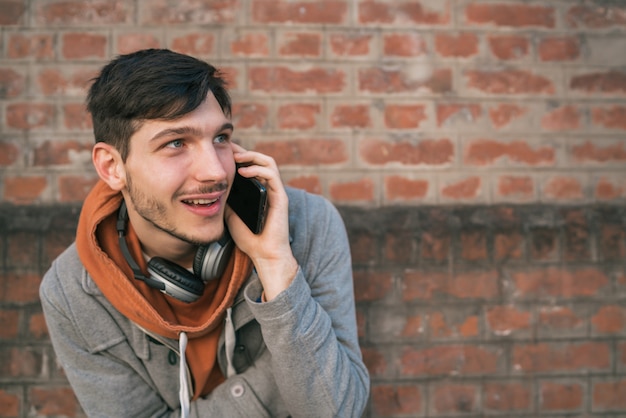 Free photo young man talking on the phone outdoors.