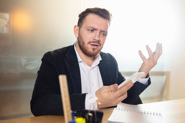 Young man talking, working during videoconference with colleagues at home office