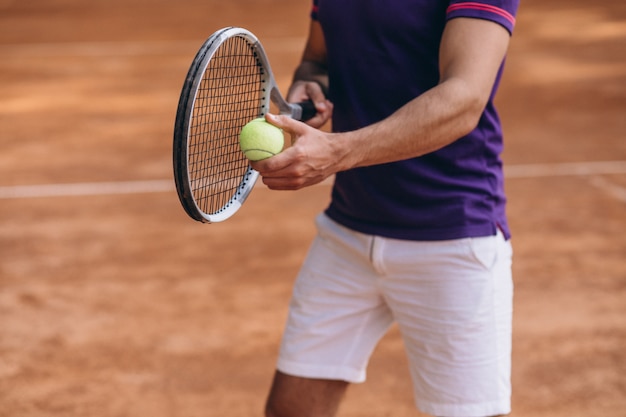 Young man tennis player at the court, tennis racket close up