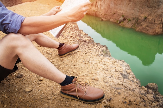 Young Man Traveler with backpack relaxing outdoor with rocky mountains on background Summer vacations and Lifestyle hiking concept.