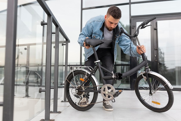 Free Photo young man using a folding bike in the city