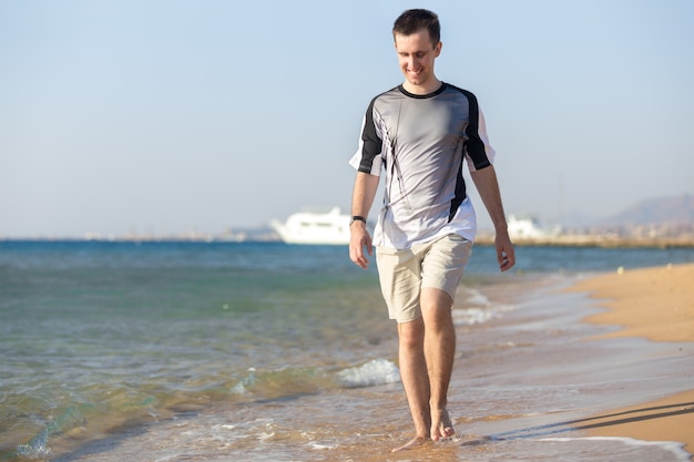 Young man walking on the shoreline