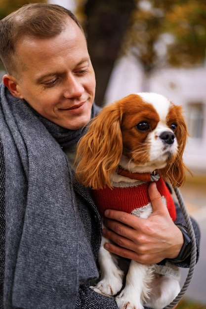 Young man walking with a dog in the autumn park