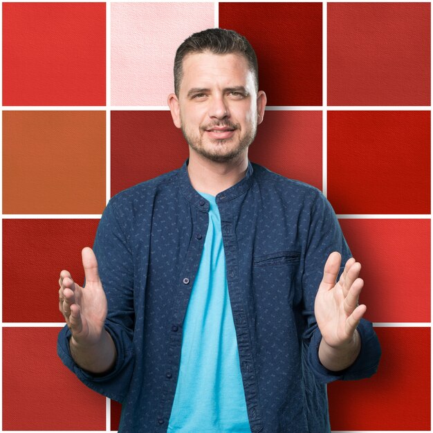 Young man wearing a blue outfit. Doing a holding gesture.