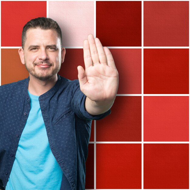 Young man wearing a blue outfit. Doing stop gesture.