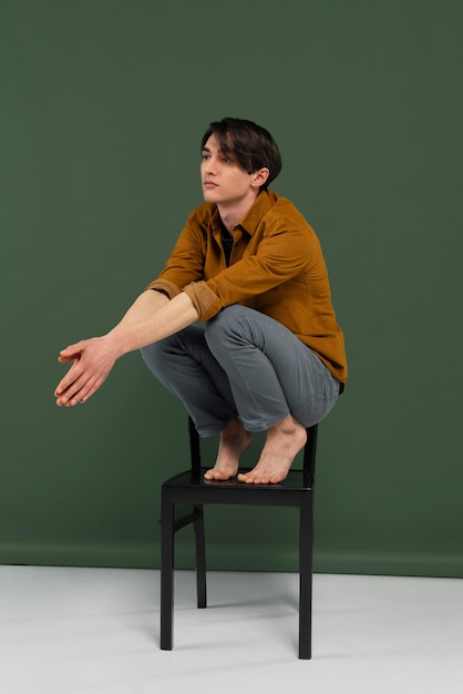 Young man wearing shirt posing on chair