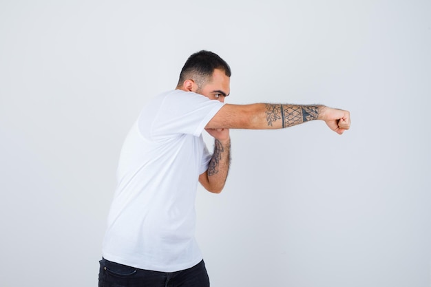 Young man in white t-shirt boxing and looking powerful