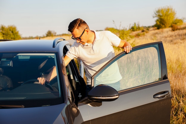 Young man in white t-shirt holding the steering wheel