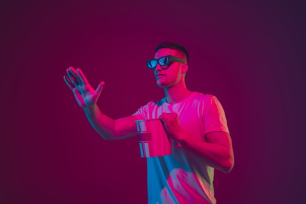 Free Photo young man with 3d glasses and popcorn bucket