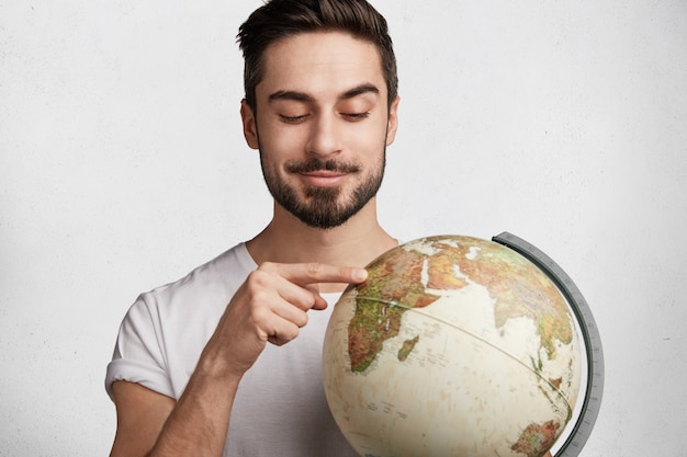 Free photo young man with beard and globe