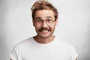 Free photo young man with beard and round glasses