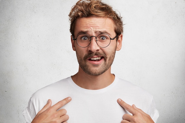 Free photo young man with beard and round glasses