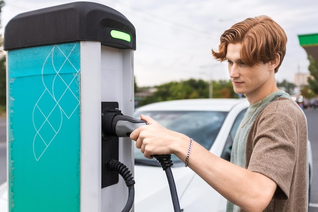 Young man with an electric car at charging station in Chisinau Moldova