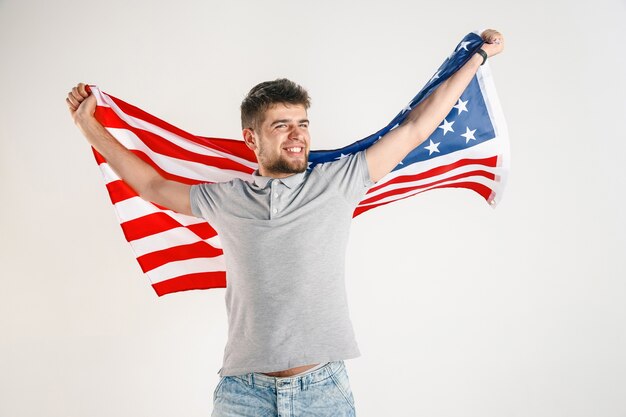 Young man with the flag of the United States of America isolated on white studio.