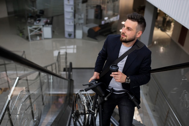 Young man with folding bike on escalator