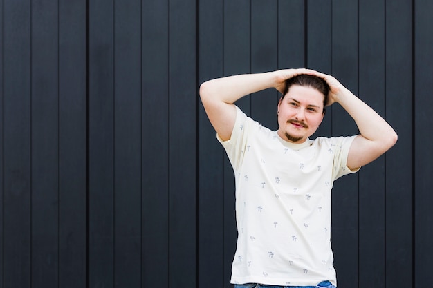 Free Photo young man with his hand on head looking at camera