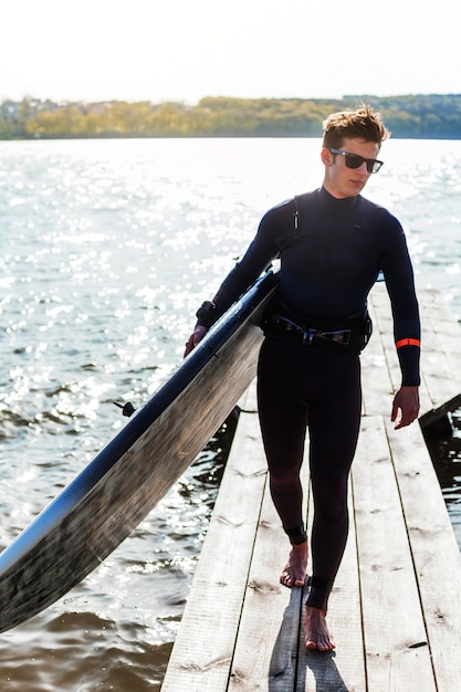 Young man with kitesurf board