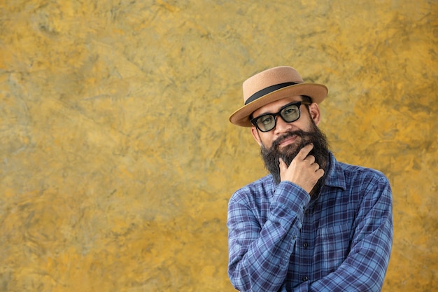 Young man with a long beard wearing a hat and glasses