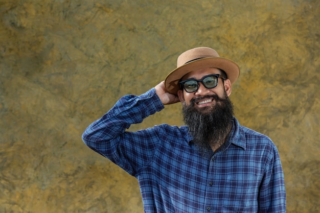 Free photo young man with a long beard wearing a hat and glasses