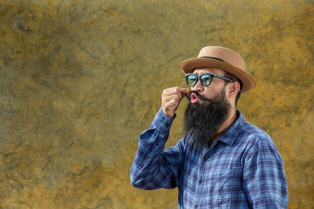 Young man with a long beard wearing a hat and glasses