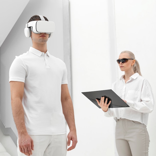 Free photo young man with virtual reality simulator and woman testing