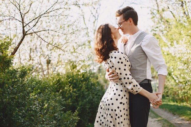 Young man and woman couple in a blooming garden