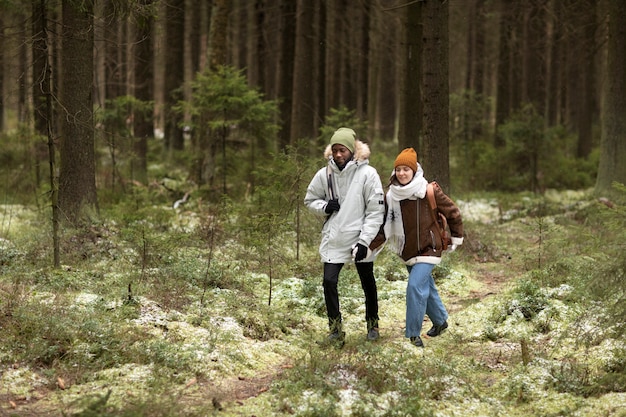 Young man and woman in a forest together during a winter road trip