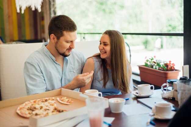 Young man and woman spending time together in pizzeria