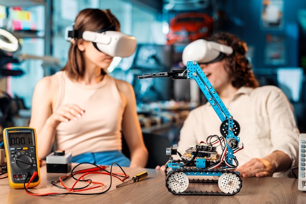 Free photo young man and woman in vr glasses doing experiments in robotics in a laboratory robot and tools