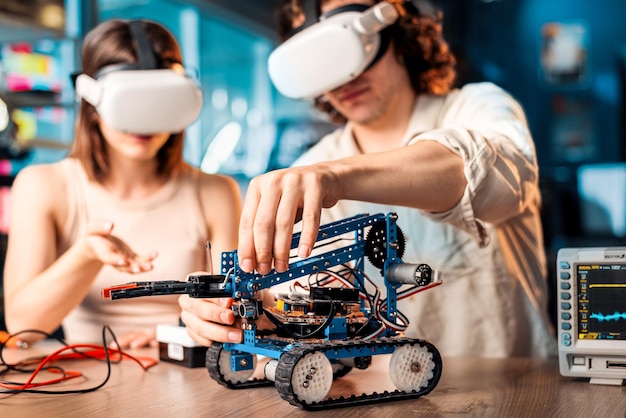 Free Photo young man and woman in vr glasses doing experiments in robotics in a laboratory robot and tools