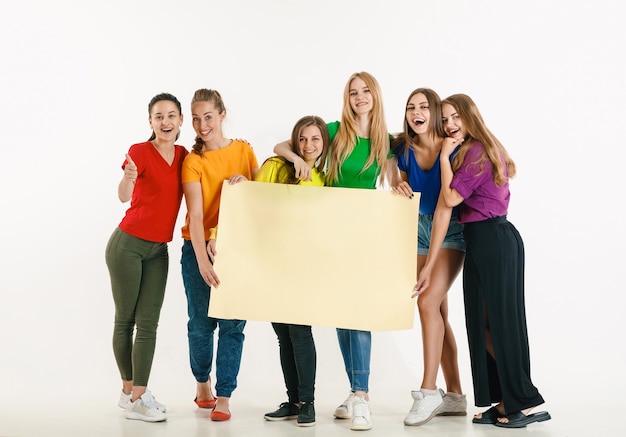 Free Photo young man and woman weared in lgbt flag colors on white wall. models in bright shirts