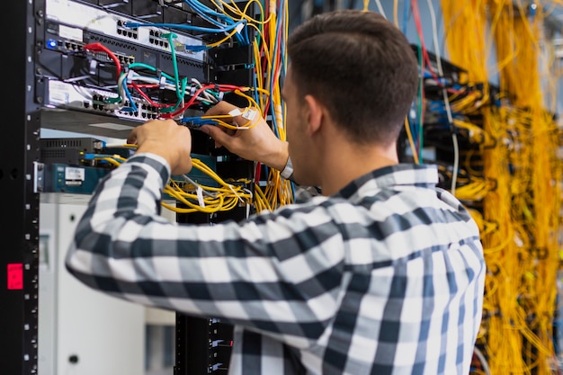 Free Photo young man working on an ethernet switch