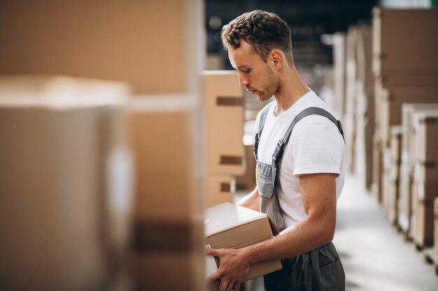 Young man working at a warehouse with boxes