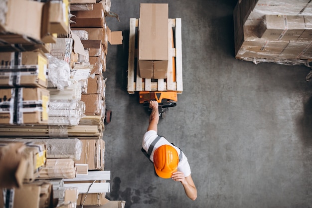 Free Photo young man working at a warehouse with boxes