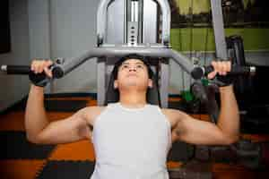 Free photo young man workouts at fitness gym